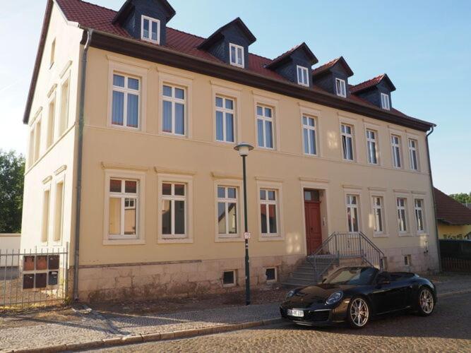 une voiture noire garée devant un grand bâtiment dans l'établissement Apartment in the center of Ballenstedt, à Ballenstedt