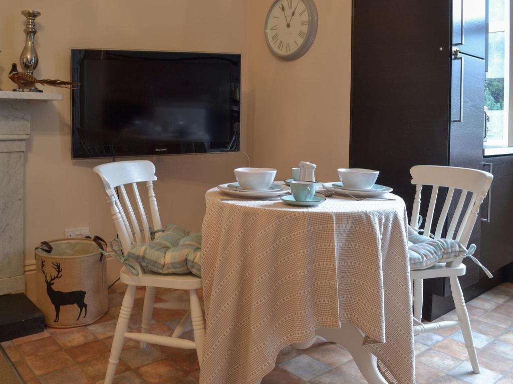 - une table avec deux chaises et une table avec deux tasses dans l'établissement Broomleasowe House, à Whittington