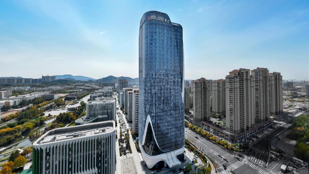 un rascacielos alto en medio de una ciudad en HUALUXE Hotels and Resorts Qingdao Licang, an IHG Hotel, en Qingdao