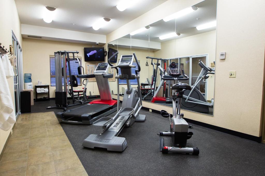 a gym with several tread machines in a room at The Kanata Fort Saskatchewan in Fort Saskatchewan