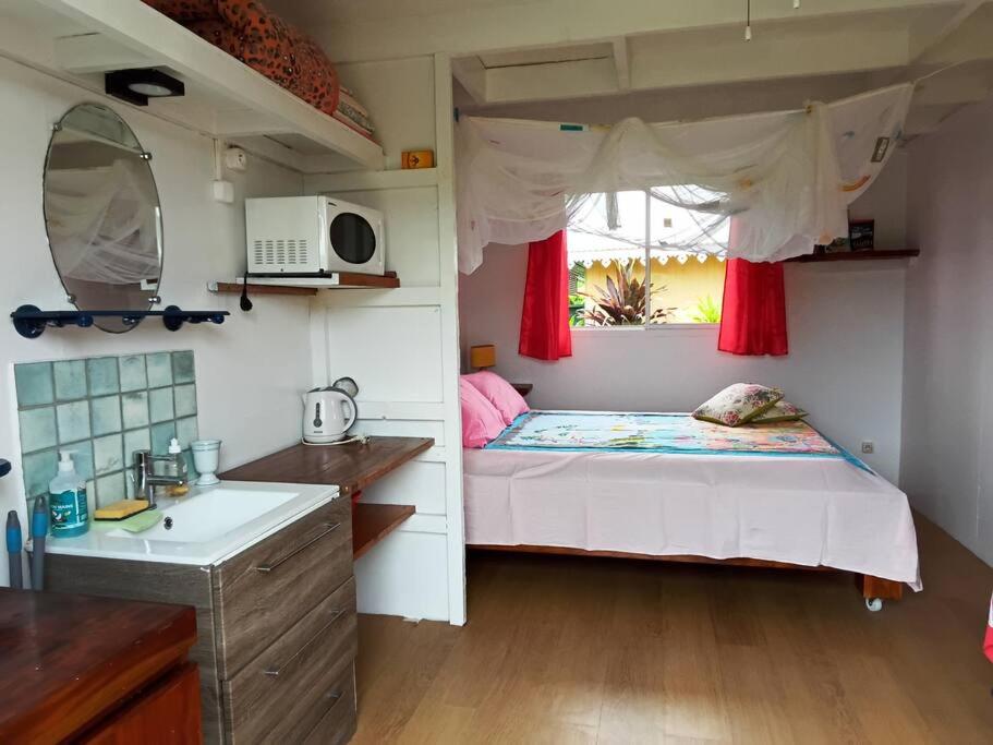 um pequeno quarto com uma cama e uma janela em TEREVAA 2 em Fare