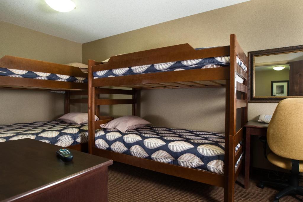 a bedroom with bunk beds with a desk and a mirror at The Kanata Fort Saskatchewan in Fort Saskatchewan