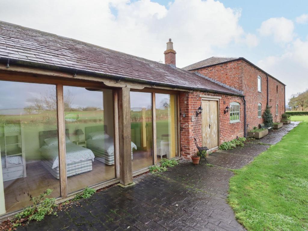 an extension to a brick house with glass windows at The Barn in Ellesmere
