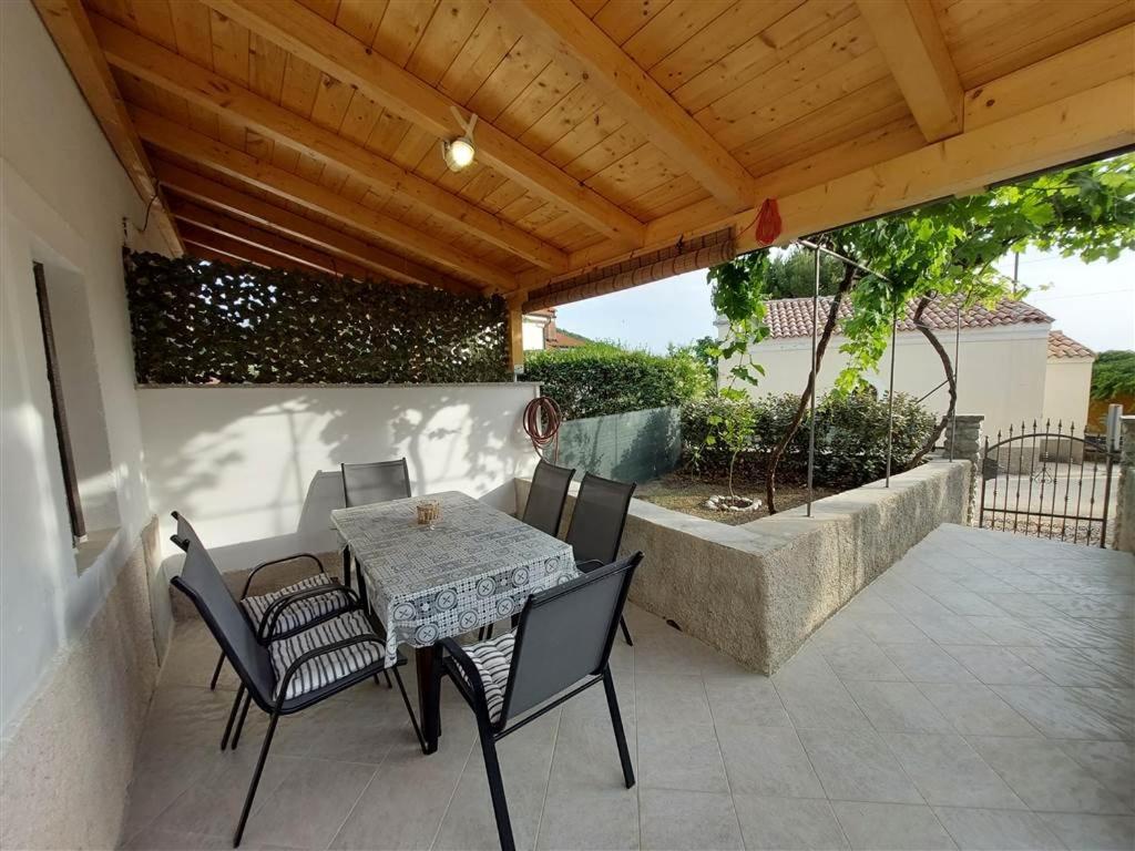 a table and chairs on a patio with a wooden roof at House Antonio in Miholascica (66-1) in Miholašćica