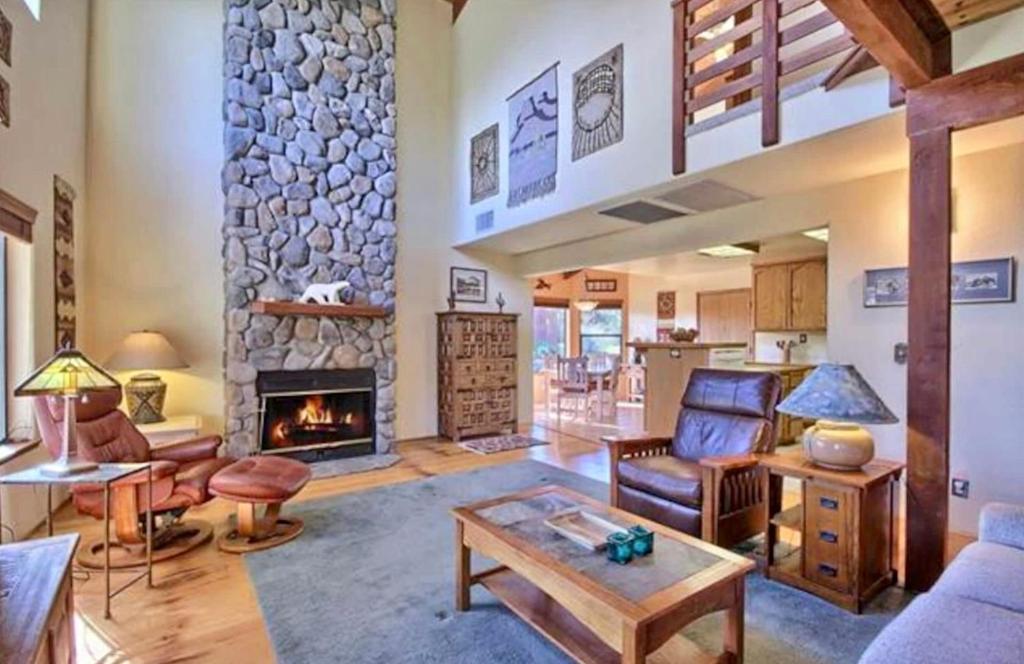 a large living room with a stone fireplace at Manzanita Ridge Estate by Bnb Yosemite in Mariposa