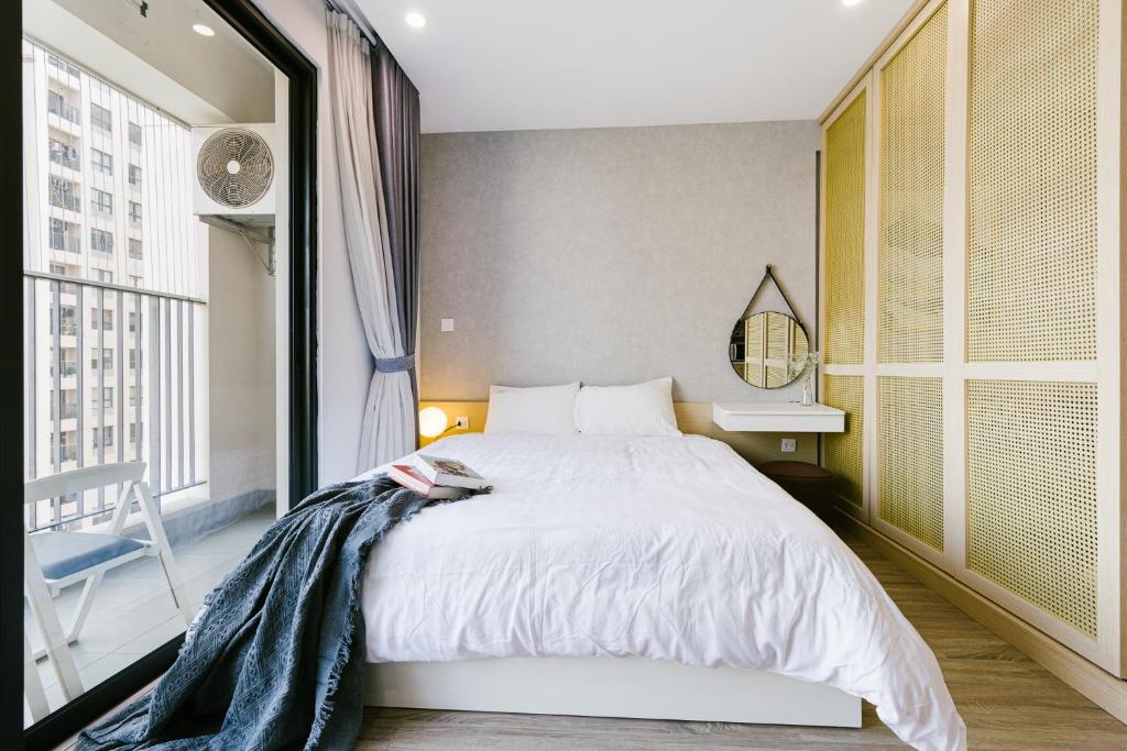 - une chambre avec un lit et une grande fenêtre dans l'établissement Happy apartment, à Hanoï