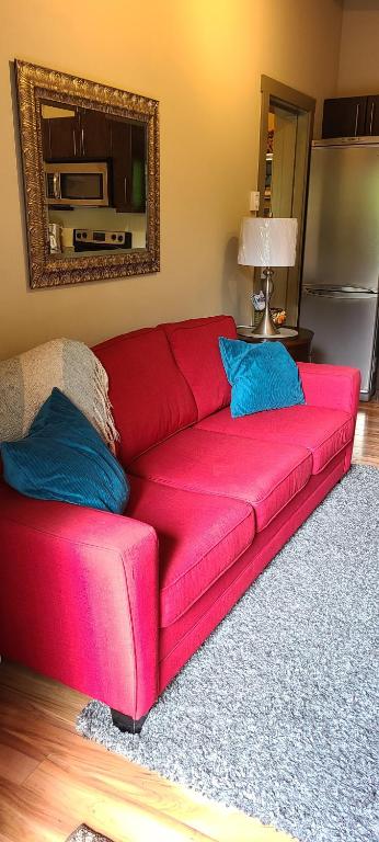a red couch with blue pillows in a living room at A Shack In The Woods in Port Renfrew
