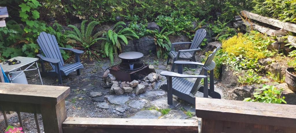 a group of chairs and a fire pit in a garden at A Shack In The Woods in Port Renfrew