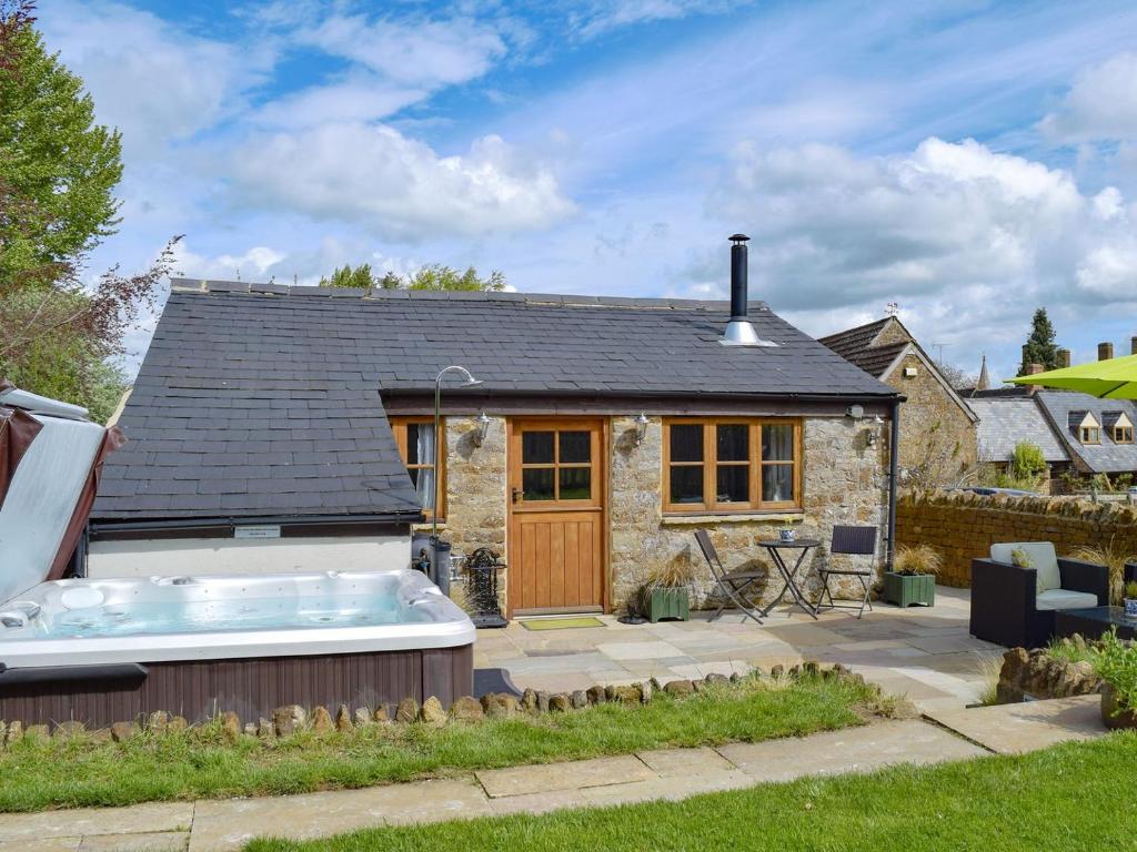 a cottage with a hot tub in front of it at The Old Stables in Swerford