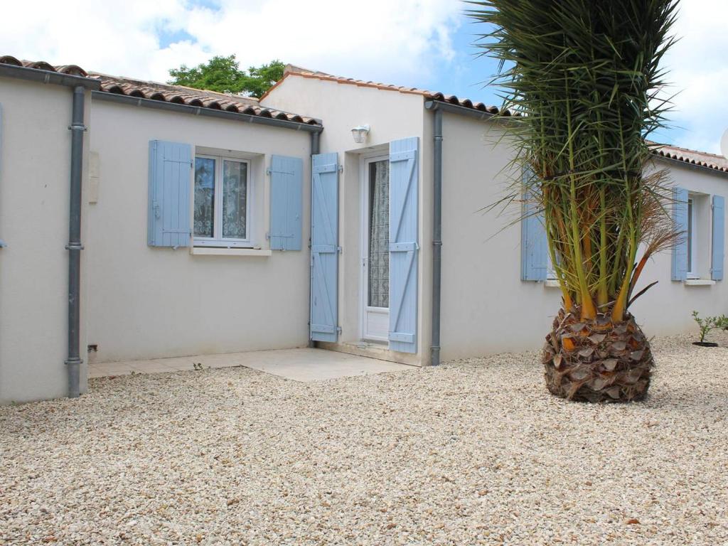 a house with blue shutters and a palm tree in front at Maison Saint-Georges-d'Oléron, 4 pièces, 6 personnes - FR-1-246A-172 in Saint-Georges-dʼOléron