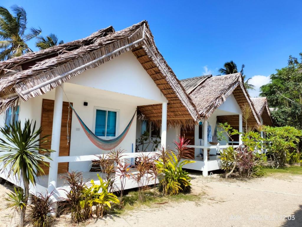 een huis met een hangmat ervoor bij Sand Terrace Beach Bungalows in Baan Tai