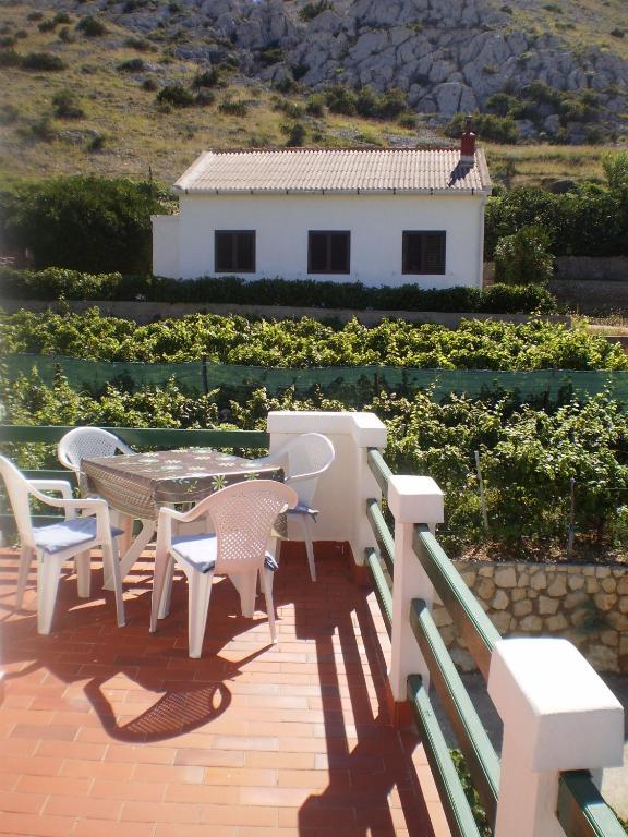 a patio with a table and chairs and a house at Apartments Pag Holiday in Pag