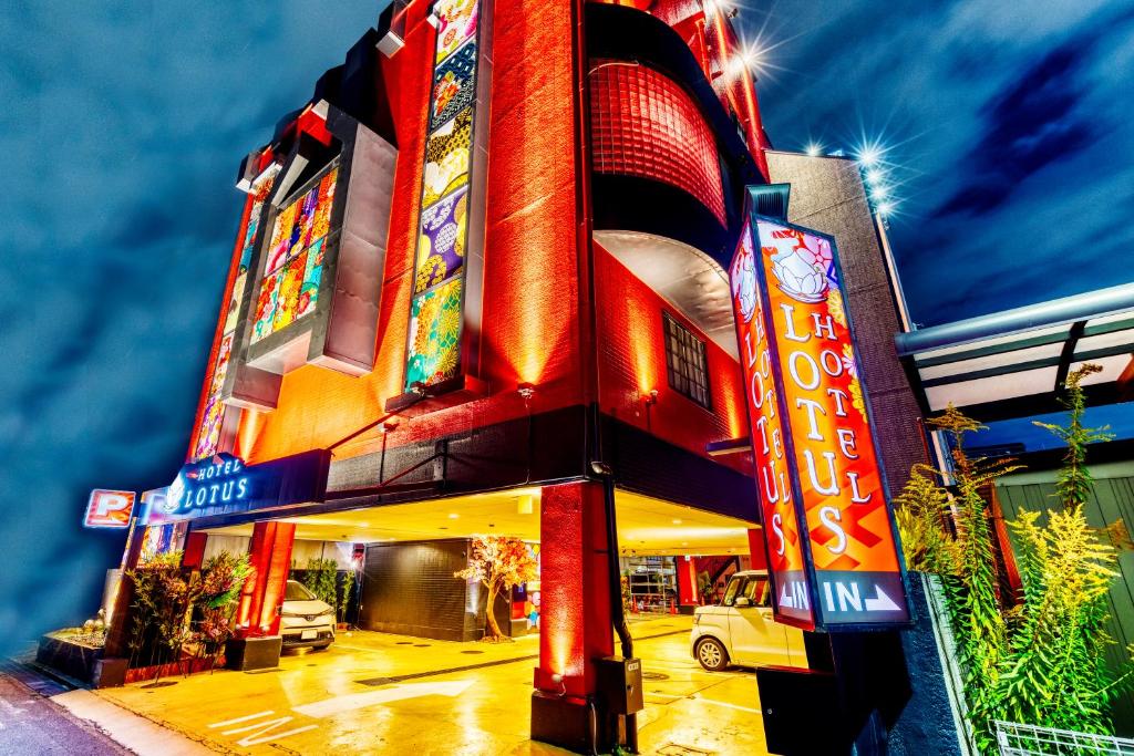 un edificio con letreros de neón en el costado en Hotel Lotus Higashiosaka -Adult Only, en Osaka