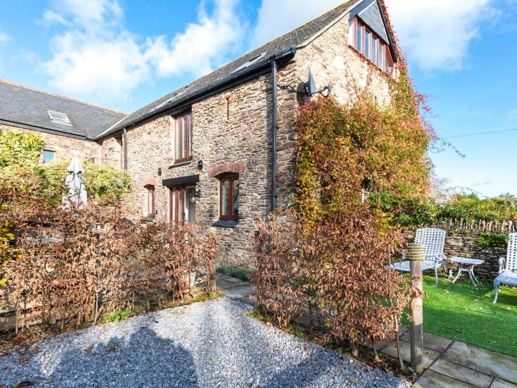 an old stone house with a garden in front of it at The Old Granary in Stoke Fleming