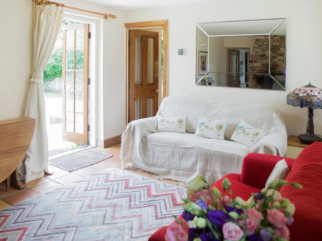 a living room with a white couch and a mirror at The Bothy in Staple