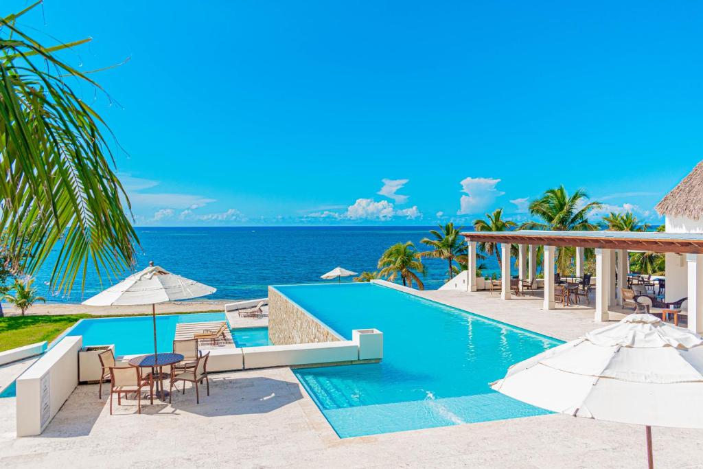 una piscina sulla spiaggia con sedie e ombrelloni di Las Verandas Hotel & Villas a First Bight