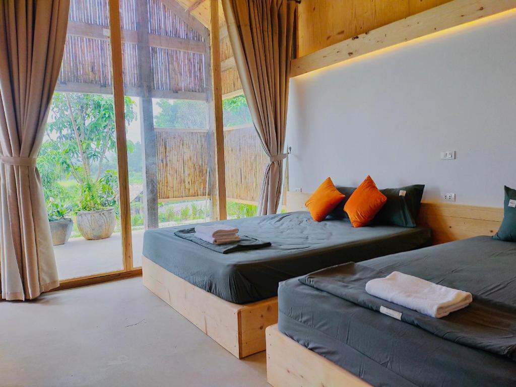 a bedroom with two beds and a large window at 6Nature Bavi Retreat in Hanoi