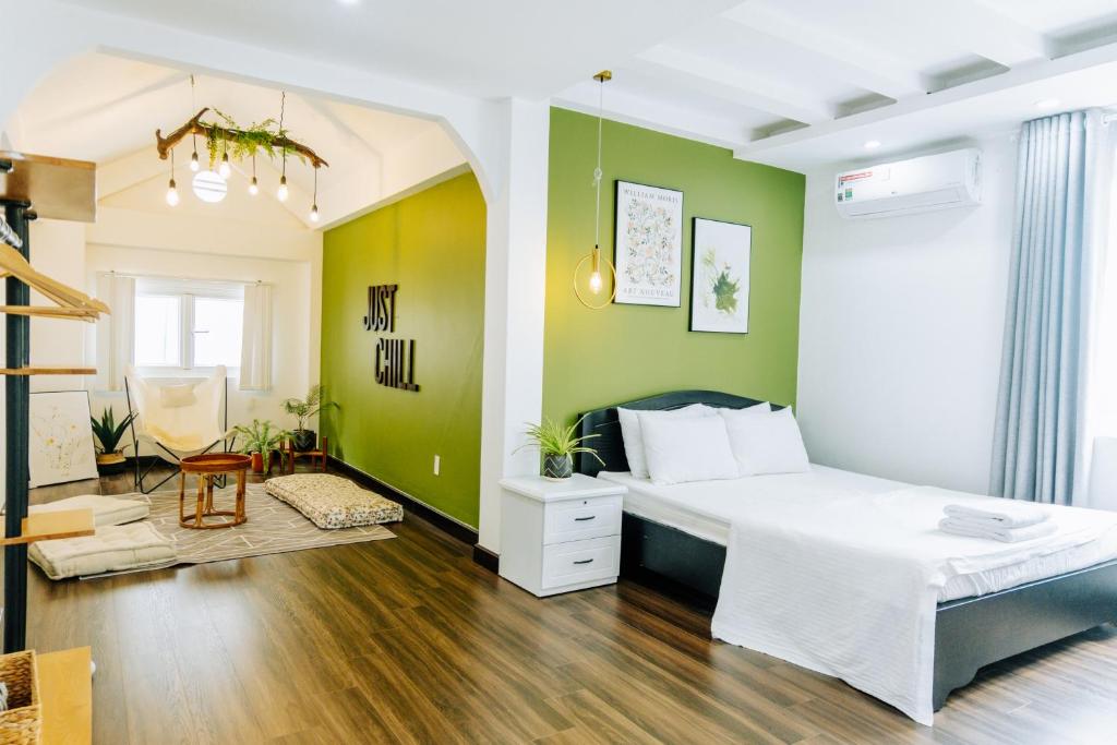 um quarto com uma cama branca e paredes verdes em Modern Greenhouse Garden View Villa in Vung Tau em Vung Tau