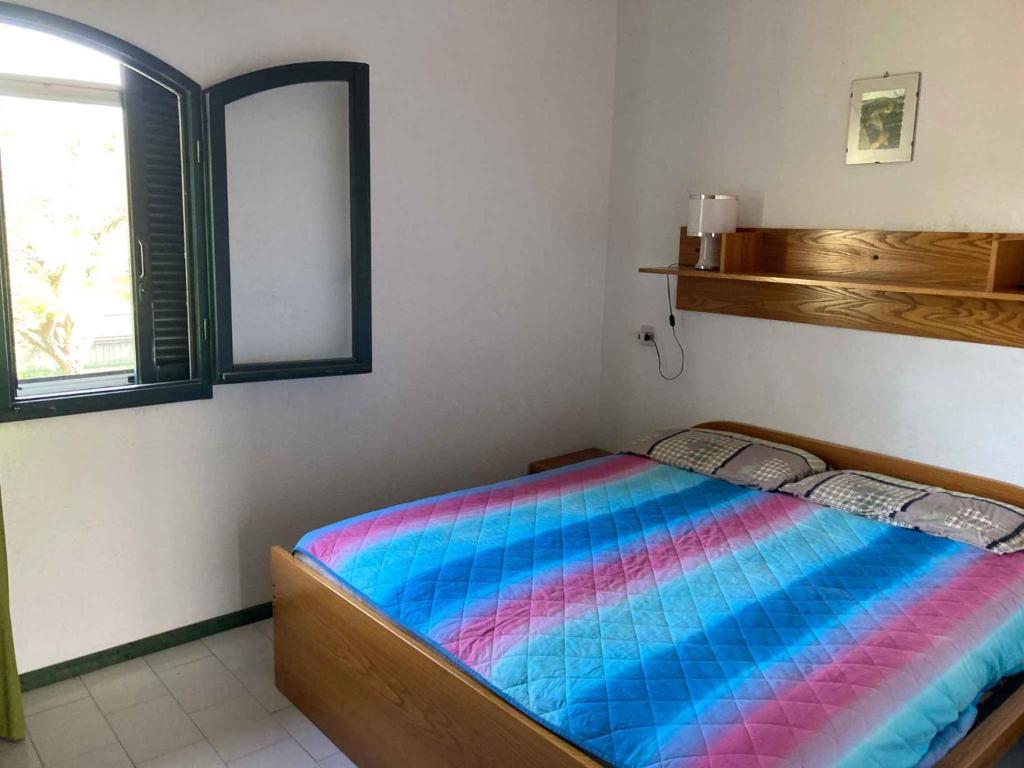 een slaapkamer met een bed met een kleurrijke deken bij Holiday home in Isola Albarella 43176 in Isola Albarella