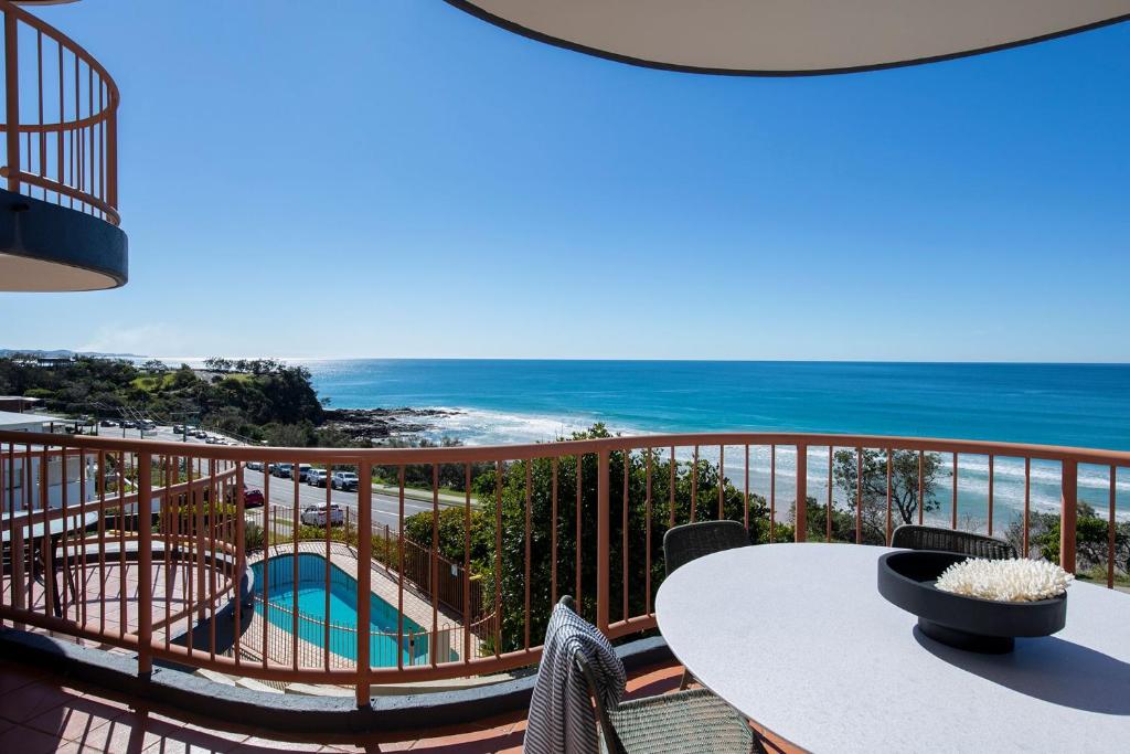 balcón con mesa y vistas al océano en Beachfront Villa, en Coolum Beach