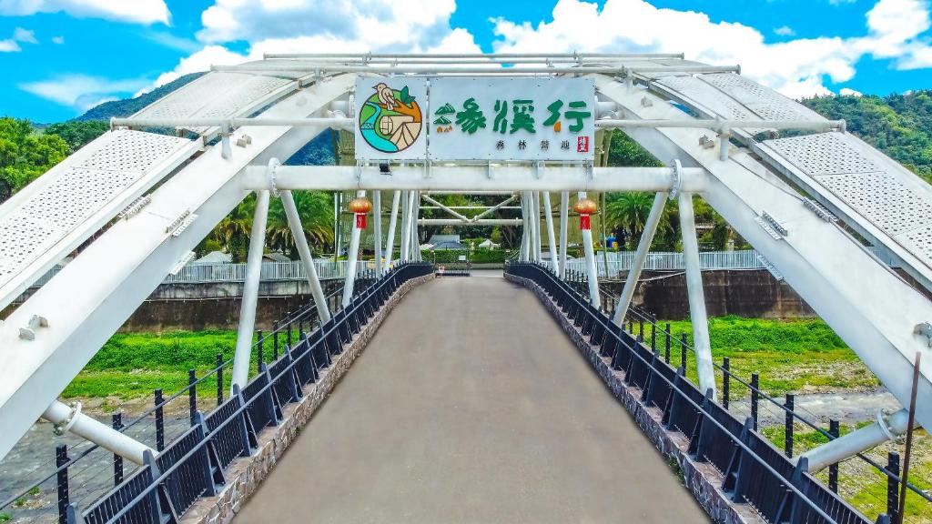 a bridge over a river with a sign on it at YCC Forest Campsite in Puli