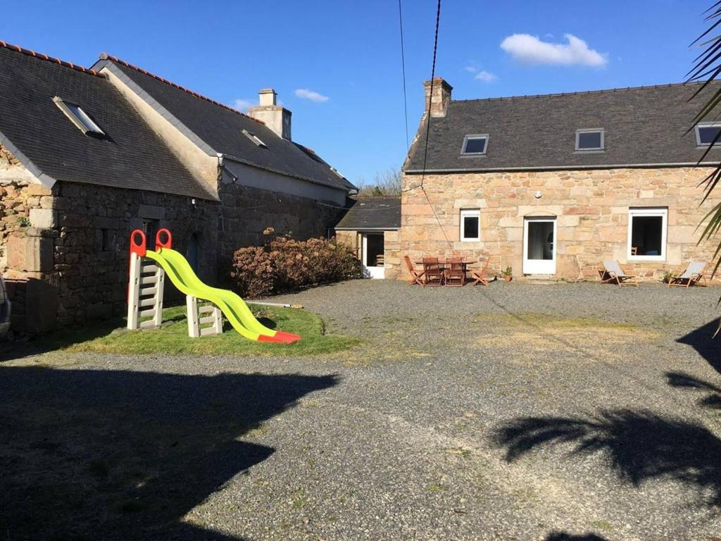 a playground with a slide in front of a house at Maison Trébeurden, 3 pièces, 6 personnes - FR-1-368-4 in Trébeurden