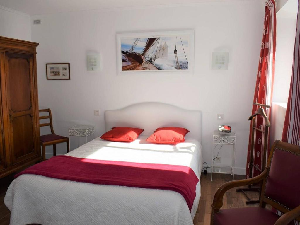 a bedroom with a bed with two red pillows at Appartement Trégastel, 2 pièces, 4 personnes - FR-1-368-77 in Trégastel