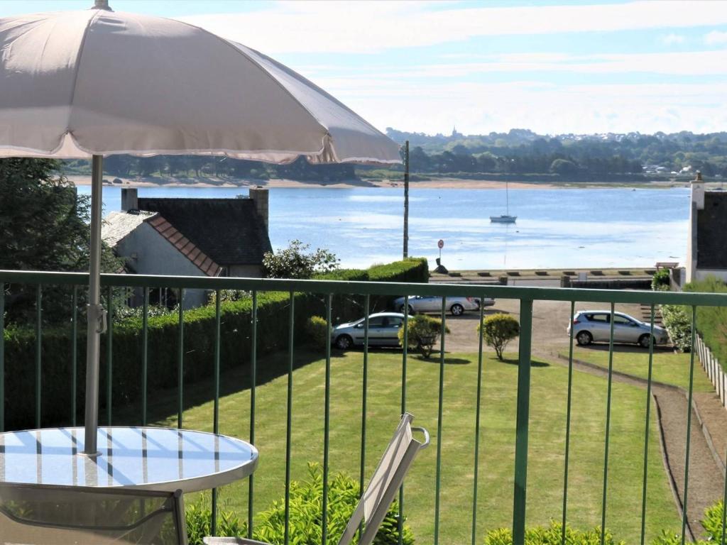 een balkon met een tafel en uitzicht op het water bij Appartement Trégastel, 1 pièce, 3 personnes - FR-1-368-122 in Trégastel