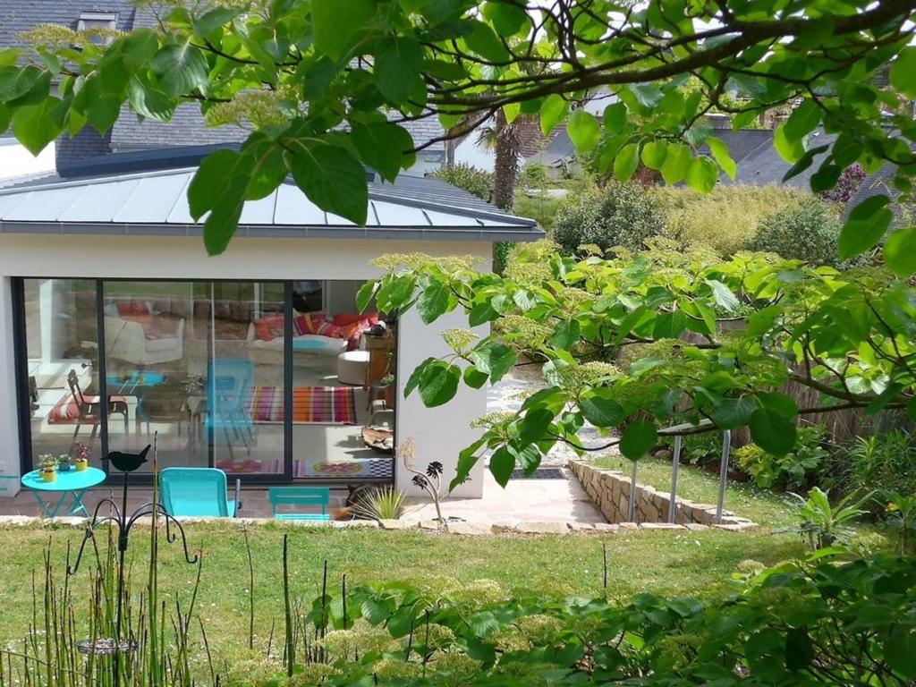 a house with a garden and some chairs in a yard at Maison Trégastel, 4 pièces, 5 personnes - FR-1-368-137 in Trégastel