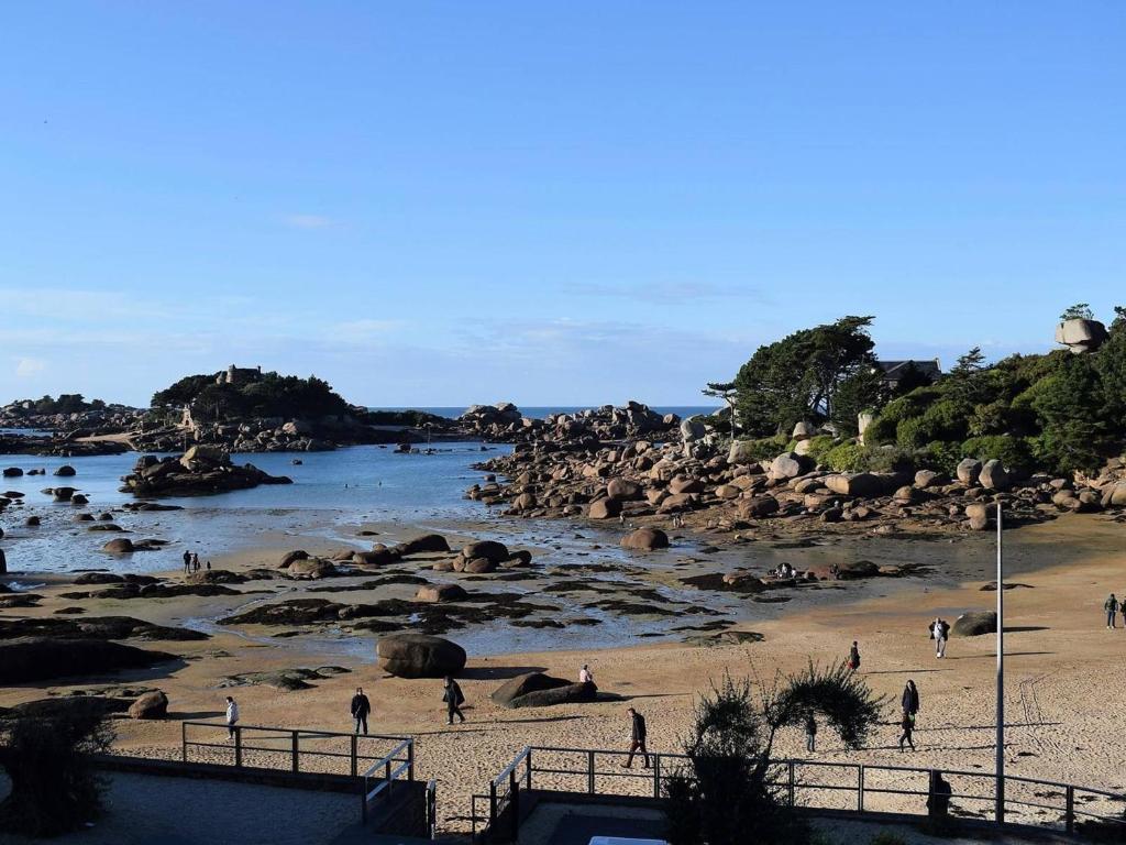un groupe de personnes marchant sur une plage à côté d'une rivière dans l'établissement Appartement 3 chambres sur la plage à Perros-Guirec - FR-1-368-138, à Perros-Guirec