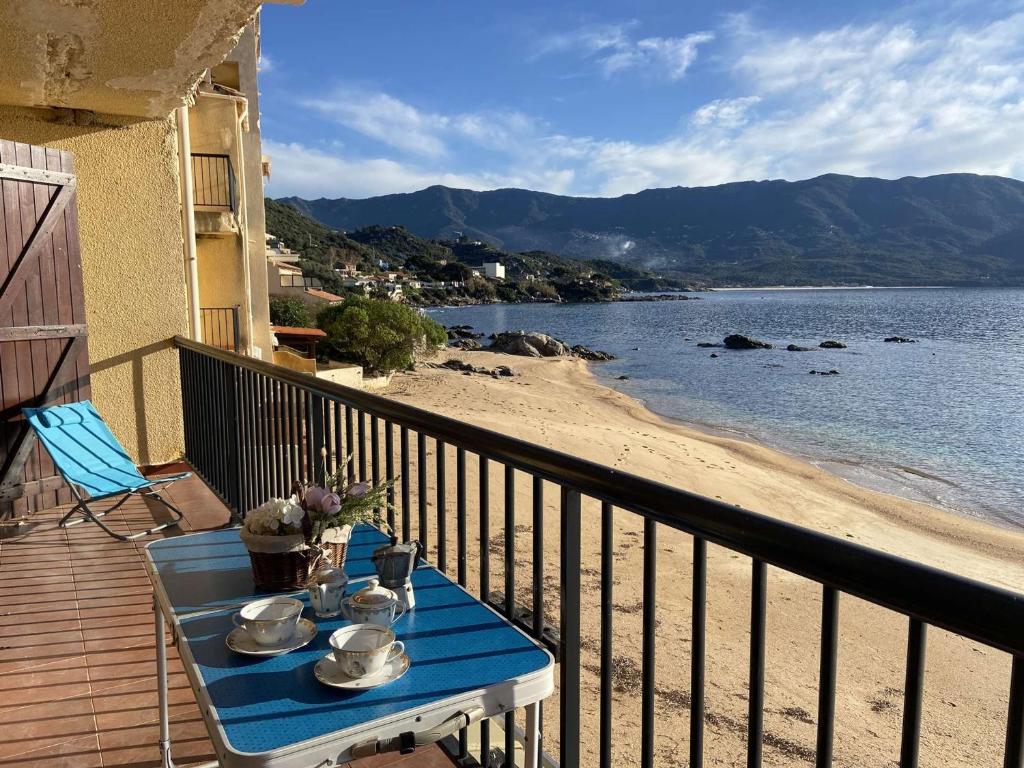 a table on a balcony with a view of the beach at Appartement Casaglione-Tiuccia, 2 pièces, 4 personnes - FR-1-61-477 in Casaglione