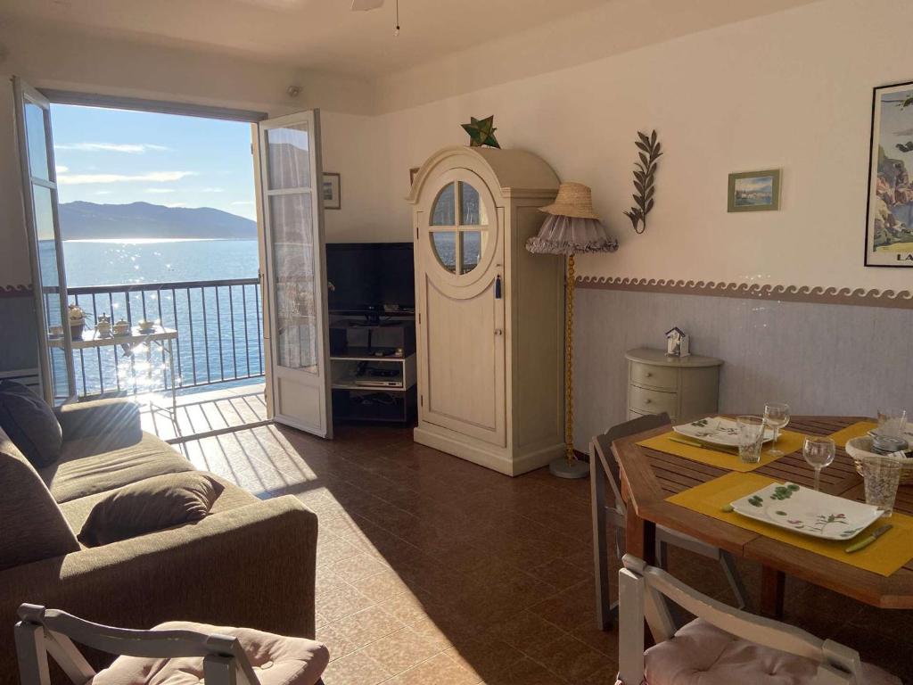a living room with a table and a view of the ocean at Appartement Casaglione-Tiuccia, 2 pièces, 4 personnes - FR-1-61-477 in Casaglione