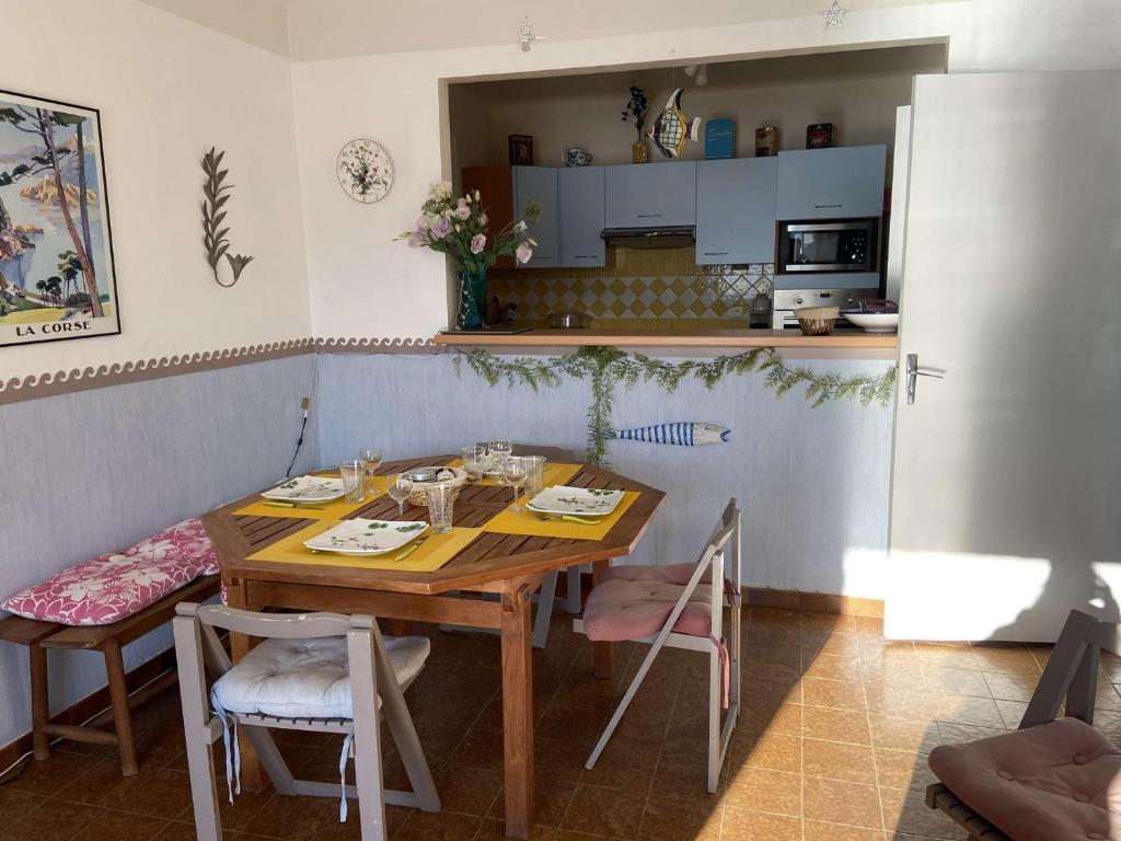 a dining room with a table and chairs and a kitchen at Appartement Casaglione-Tiuccia, 2 pièces, 4 personnes - FR-1-61-477 in Casaglione