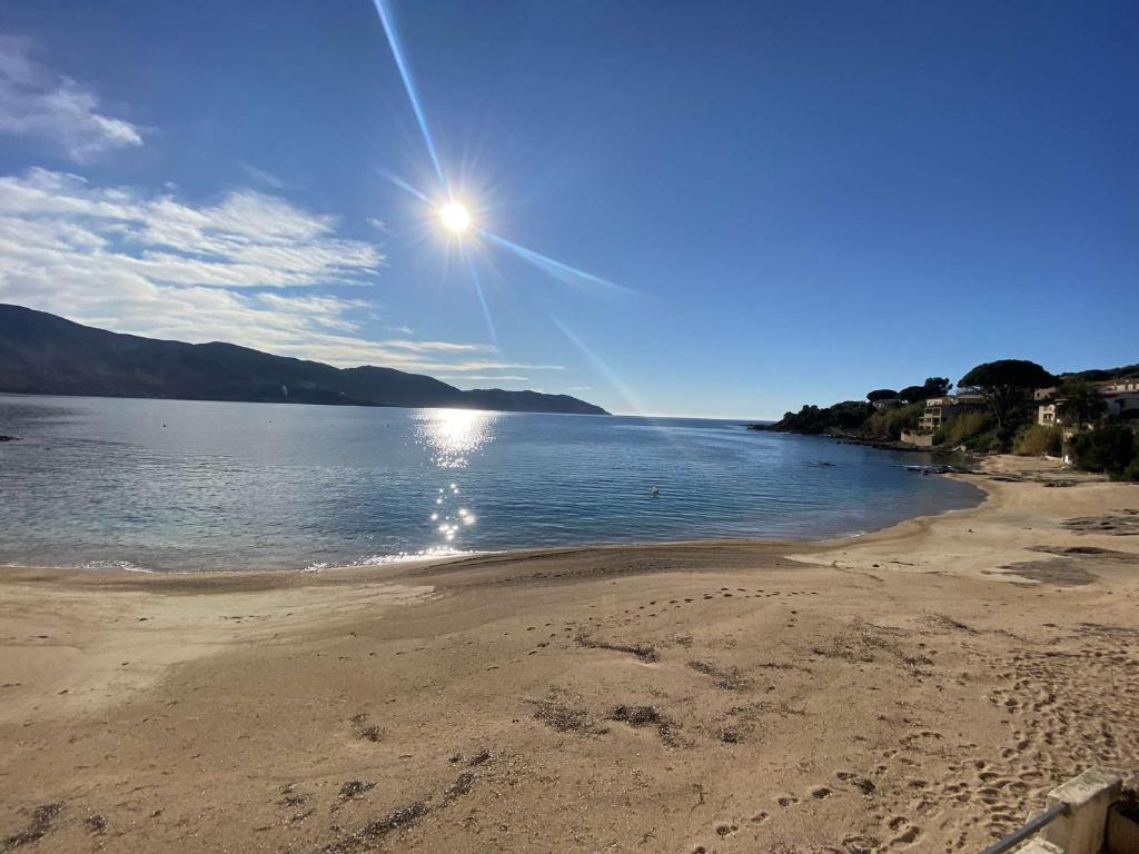 a beach with the sun shining on the water at Appartement Casaglione-Tiuccia, 2 pièces, 4 personnes - FR-1-61-477 in Casaglione