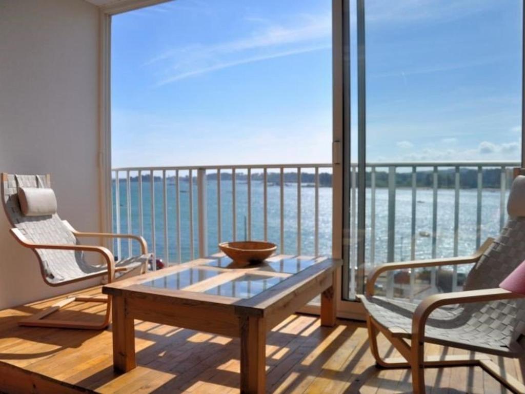 un balcon avec une table et des chaises et une vue sur l'océan dans l'établissement Appartement duplex avec terrasse, vue mer, plages à 100m, Trégastel - FR-1-368-224, à Trégastel