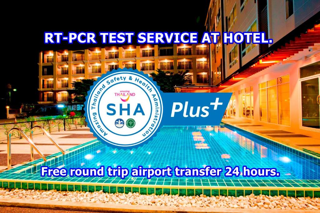 un cartel junto a una piscina frente a un hotel en Sinsuvarn Airport Suite Hotel SHA Extra Plus Certified B5040 en Lat Krabang