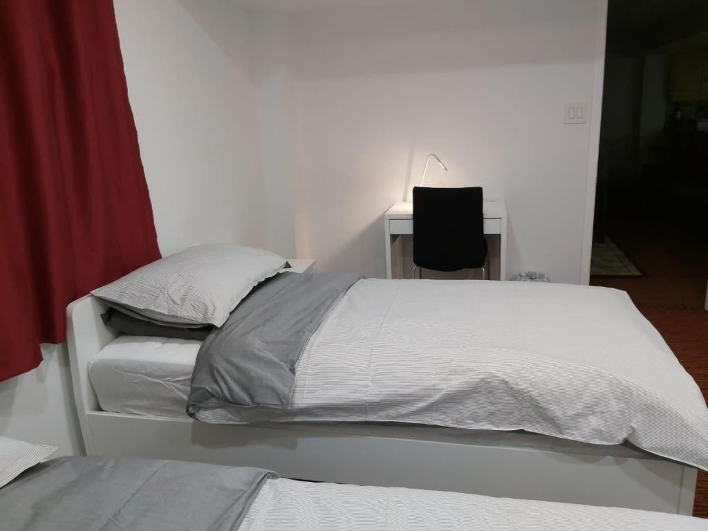 a bedroom with two beds and a desk with a lamp at Guest House Room No 03 in Mississauga