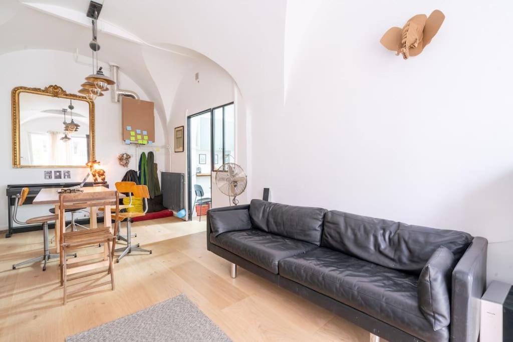 salon z czarną skórzaną kanapą i stołem w obiekcie Grand duplex Montmartre w Paryżu