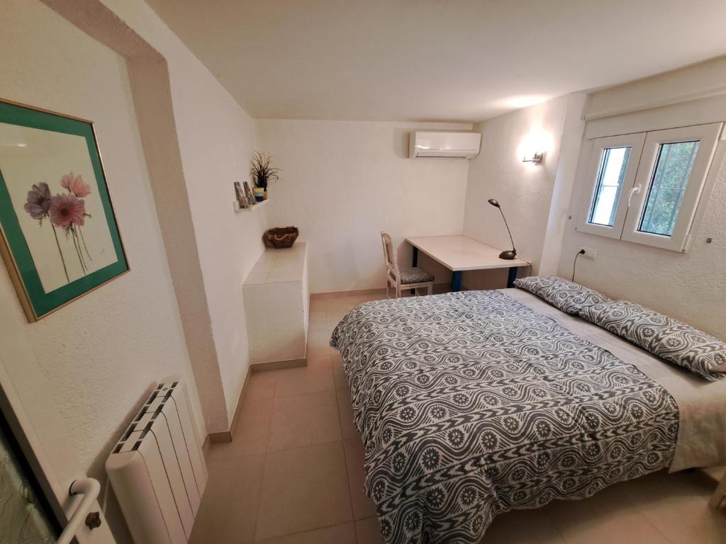 a small bedroom with a bed and a desk at la ventana al mar in Jávea