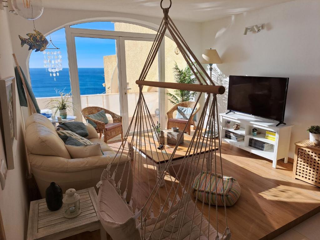 a living room with a hammock in the middle of a room at la ventana al mar in Jávea