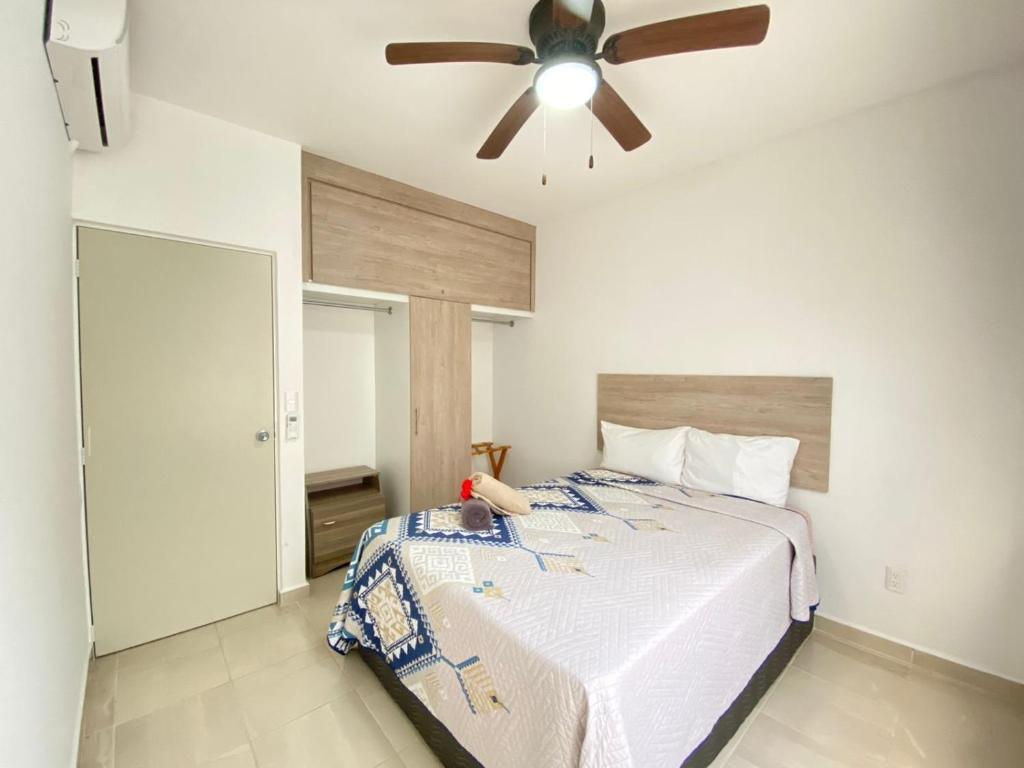 1 dormitorio con 1 cama y ventilador de techo en Apartamentos Sunset - Ciriceo III 303, en Playa del Carmen