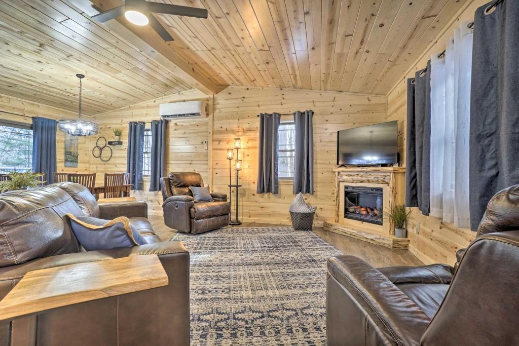 sala de estar con muebles de cuero y chimenea en Quiet Pines Cabin Hocking Hills with Hot Tub and Pond, en Logan