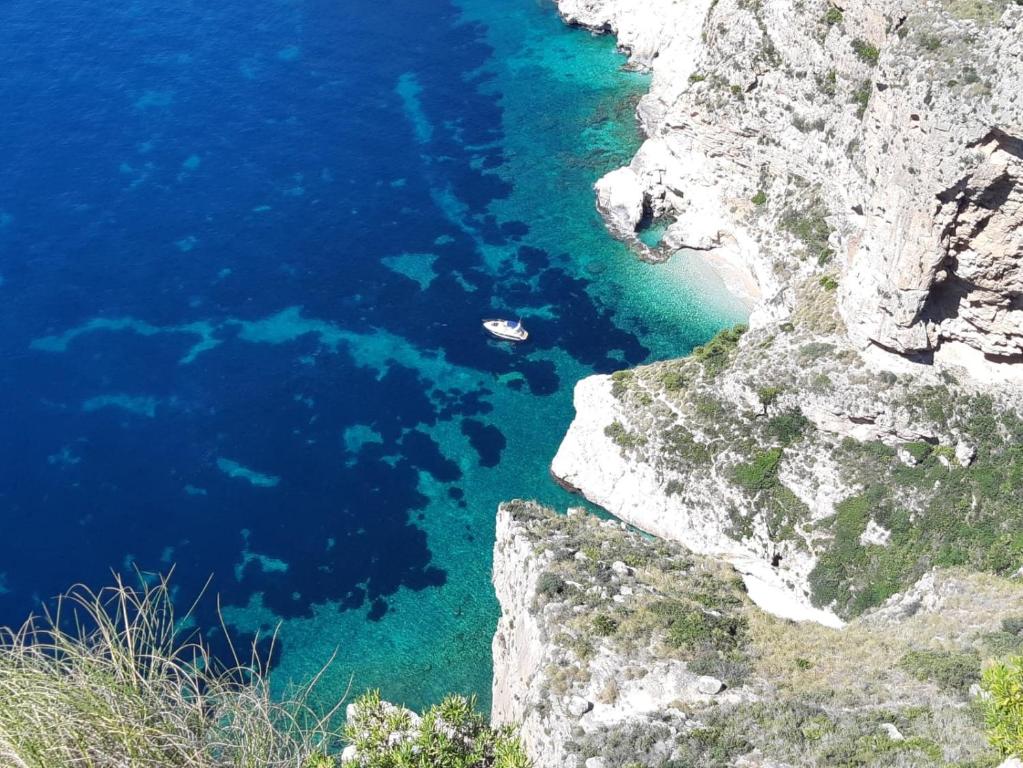 a boat in a body of water next to a cliff at la ventana al mar in Jávea
