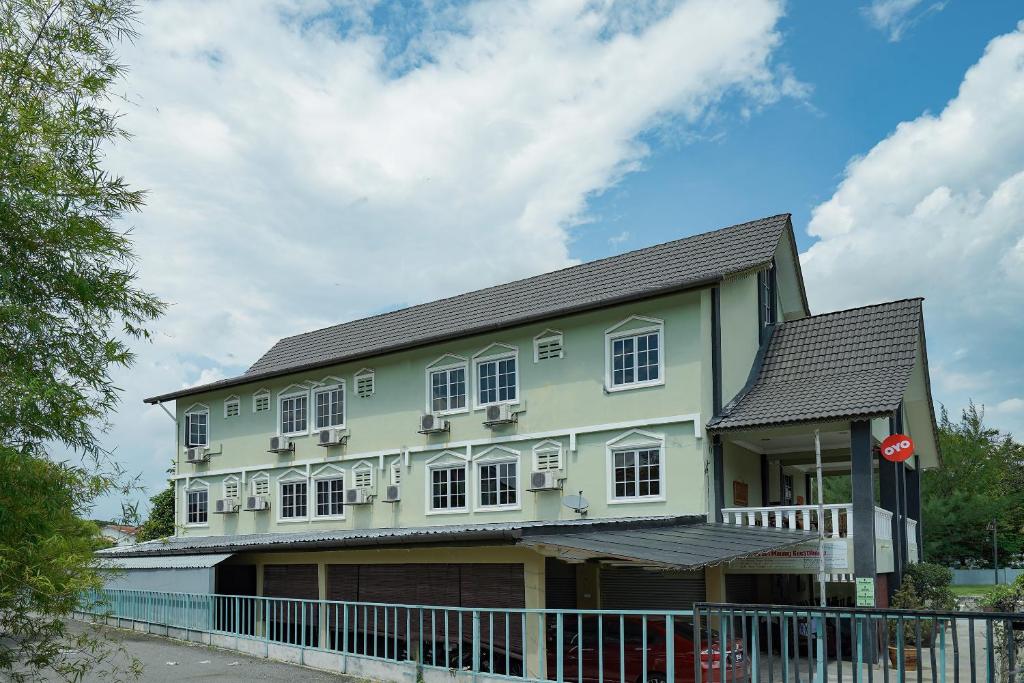 Super OYO 90009 Bangi Sri Minang Guesthouse في بانغي: بيت اخضر بنوافذ بيضاء وسوار