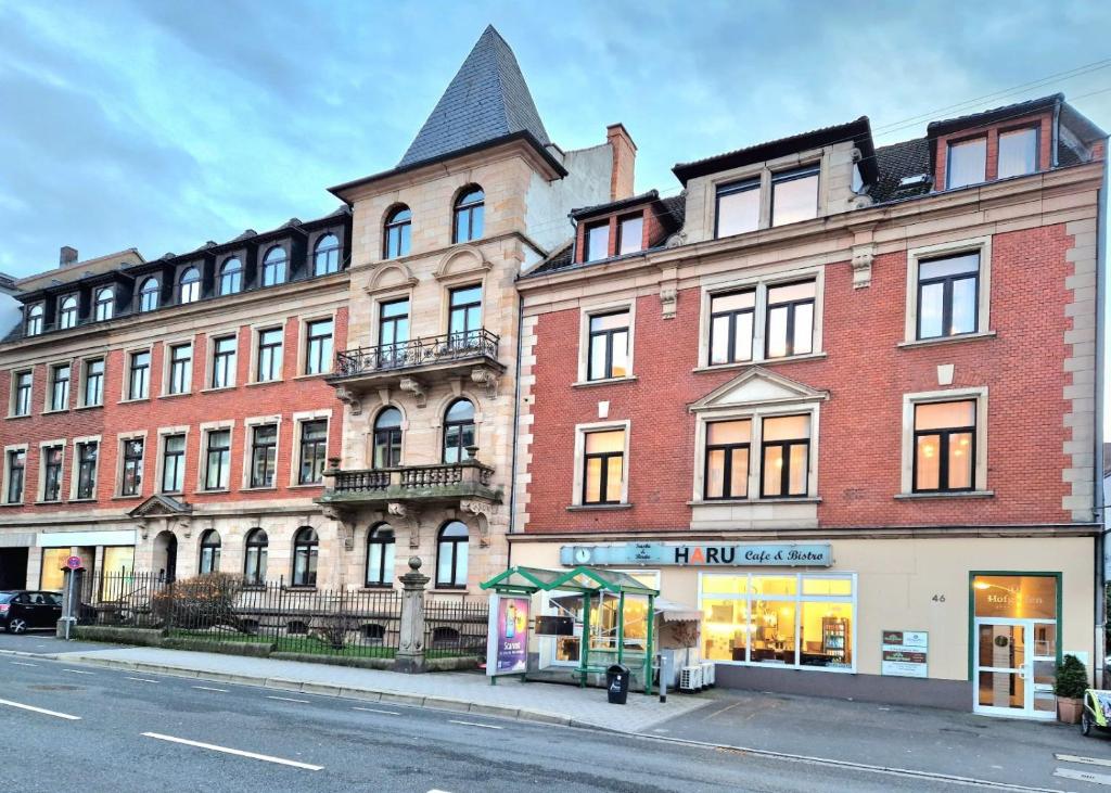 ein großes rotes Backsteingebäude in einer Stadtstraße in der Unterkunft Hofgarten Apartments in Aschaffenburg