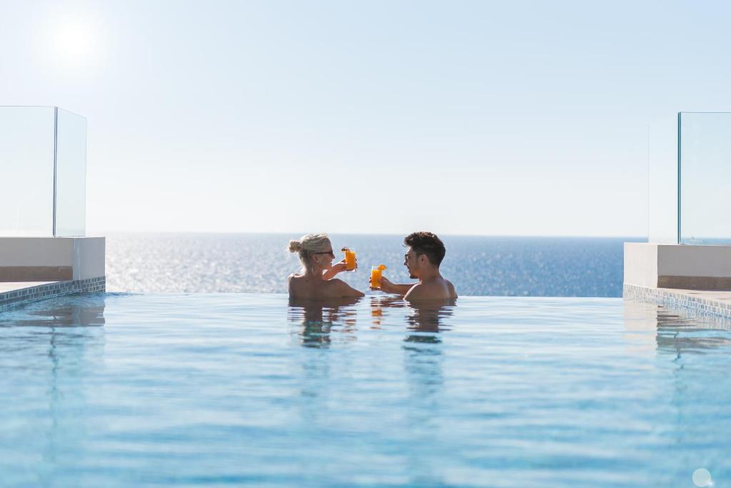 a man and a woman in a swimming pool at Cap St Georges Villas in Peyia
