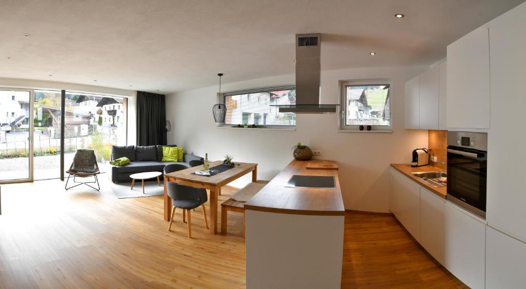 uma cozinha e sala de estar com uma mesa e um sofá em Veranda Appartement No.1 em Gries im Sellrain