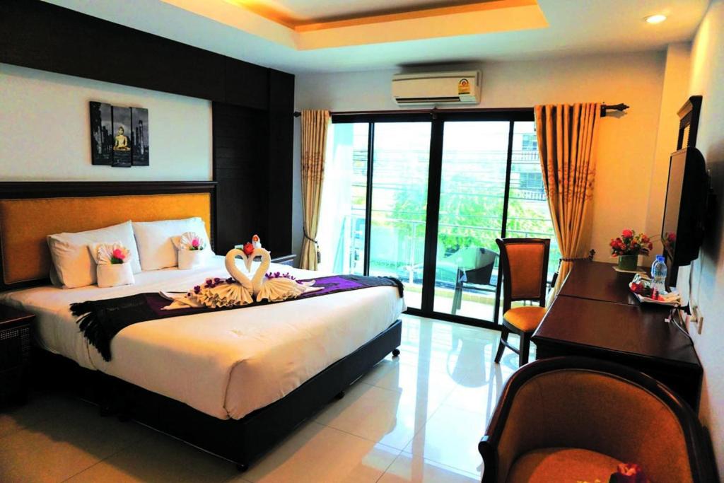 a bedroom with a bed with two birds on it at Aya Place in Pattaya South