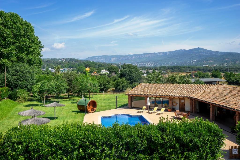 eine Villa mit einem Pool und einem Haus in der Unterkunft Agroturisme Can Burguès in Santa Eulalia de Ronsaná