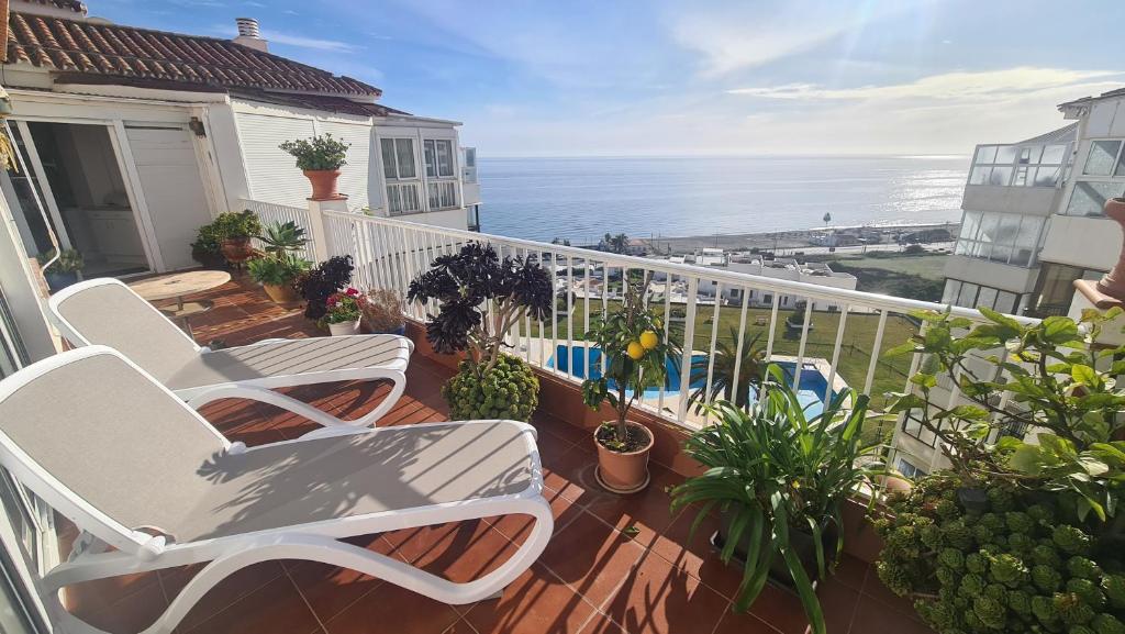 balkon z 2 krzesłami i widokiem na ocean w obiekcie Penthouse Vistamar Torrox Costa w mieście Torrox Costa